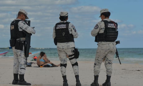 Tourists bask on a battlefield as drug gangs fight over Mexican resort town